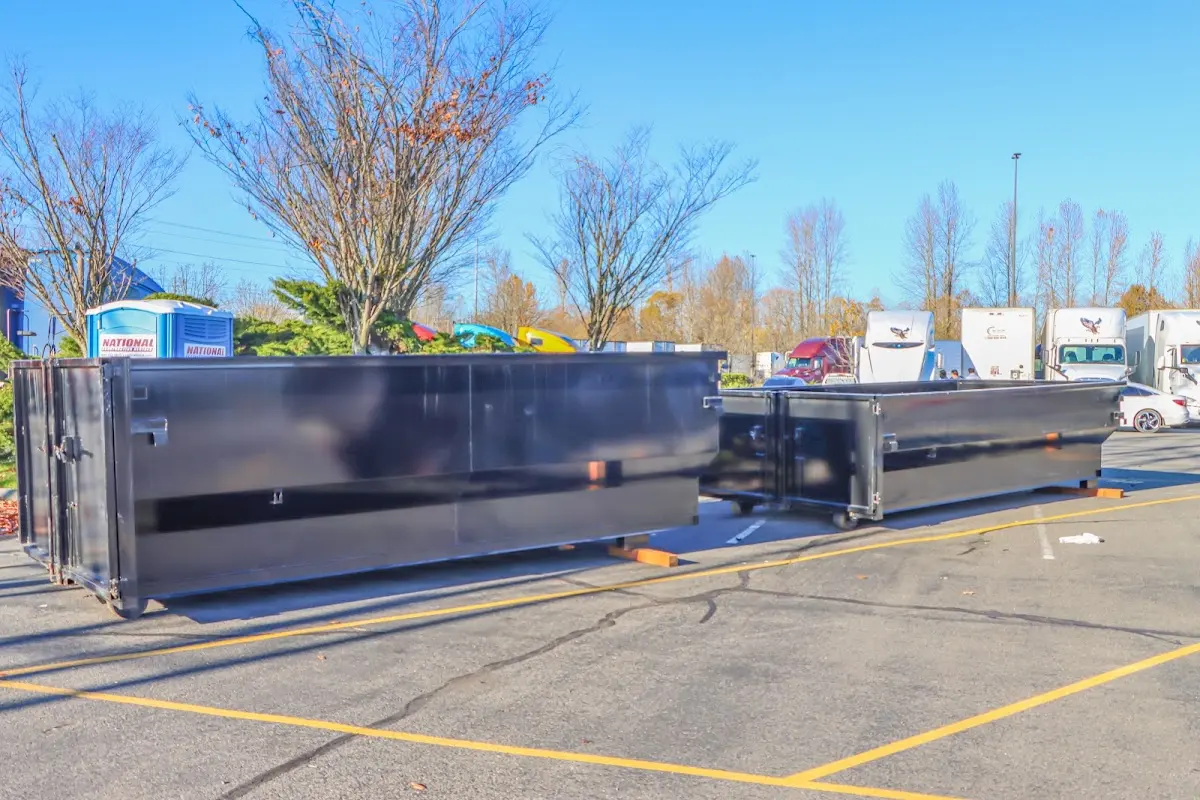 Professional dumpster rental service with roll-off container on residential driveway in Winton